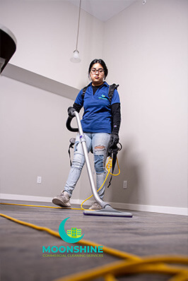 Woman using Vacuum to Clean carpets in Rexburg Building
