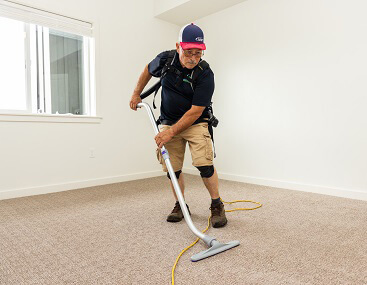 Moonshine employee floor cleaning in Blackfoot using vacuum