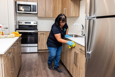 Woman wiping new kitchen counter for post construction cleaning services in Rexburg