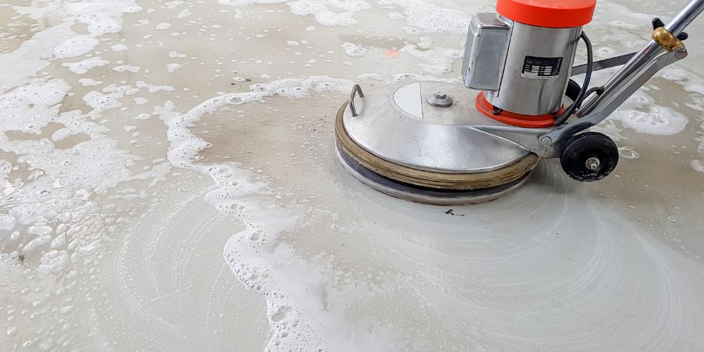 Industrial concrete floor being cleaned with a floor scrubber
